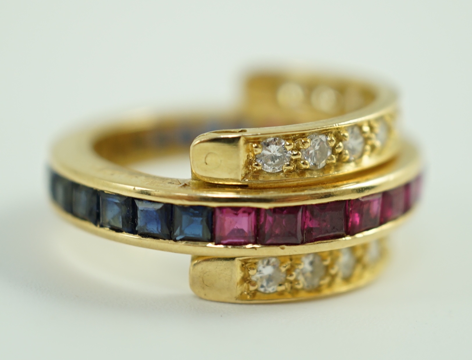An 18k gold, ruby, sapphire and diamond set triple band swivel ring